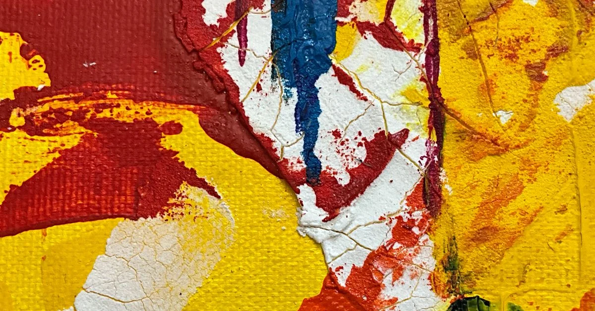 Gros plan sur une œuvre d'art abstraite colorée sur toile avec des textures rouges, jaunes et bleues.